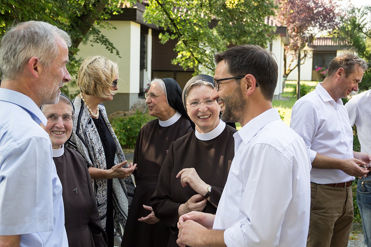 Personengruppe im Gespräch mit Ordensschwestern