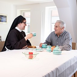 Sr. Luzia Reiter beim Kaffee-Tratsch mit einem älteren Mann