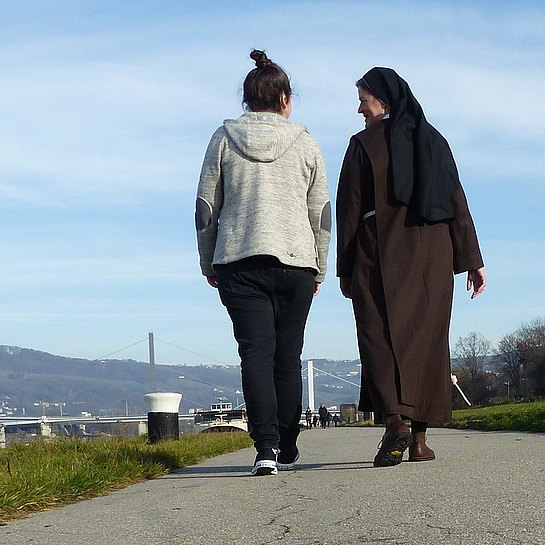 Ordensschwester mit einer Frau beim Spaziergang